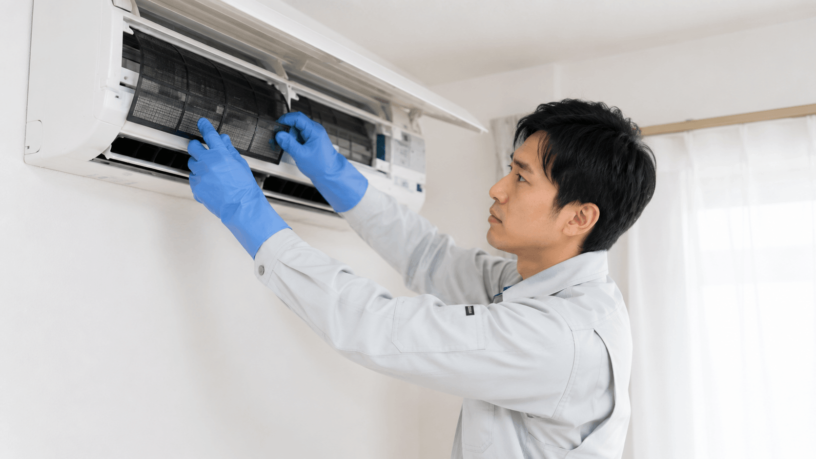 エアコンクリーニングをする作業着姿の男性