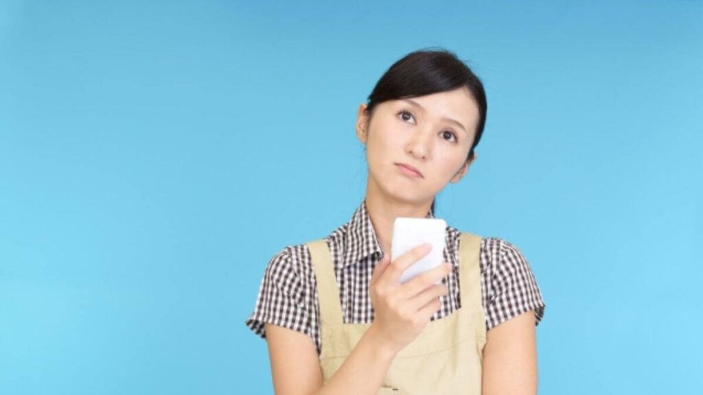 スマホを片手に疑問を感じる主婦
