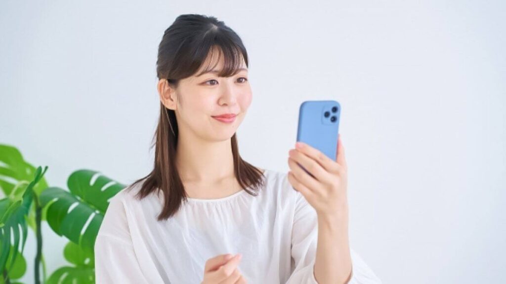 笑顔でスマホを使う若い女性