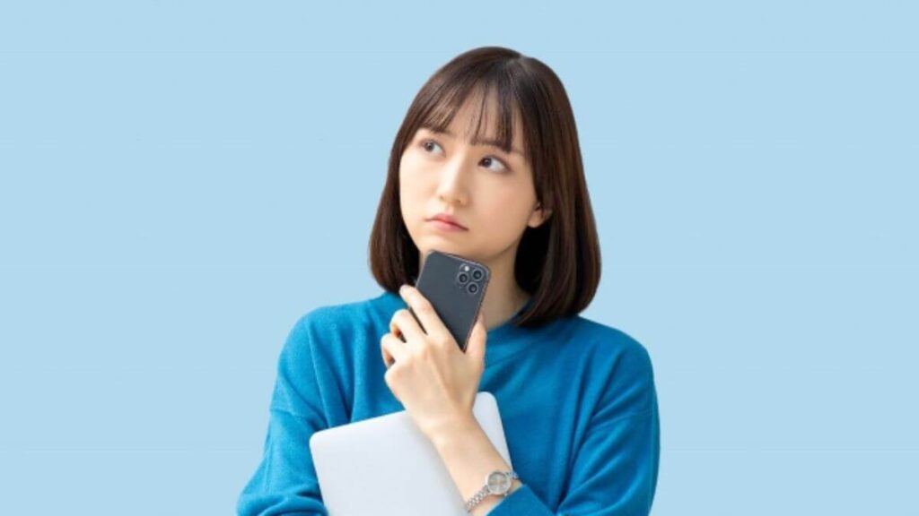 パソコンを抱え疑問を感じる若い女性