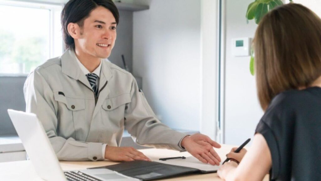 お客さんに説明する作業着姿の男性