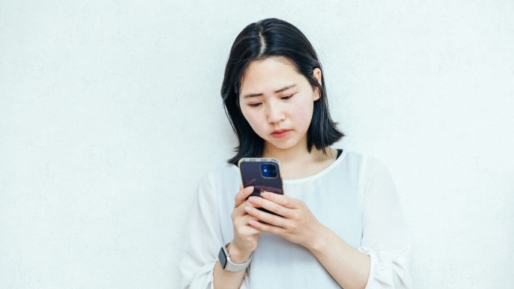 スマホで情報を探す若い女性