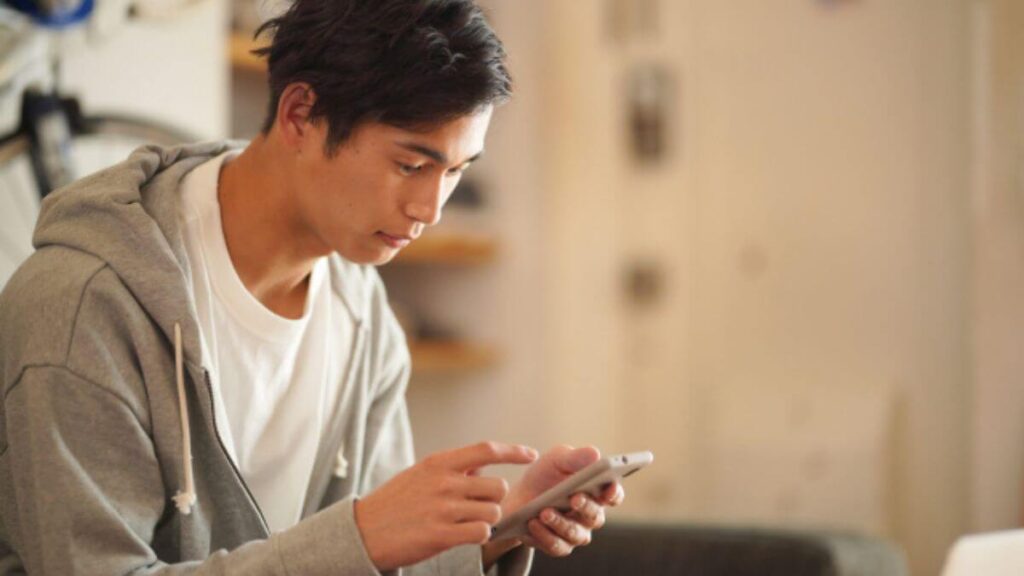 スマホで情報を探す若い男性