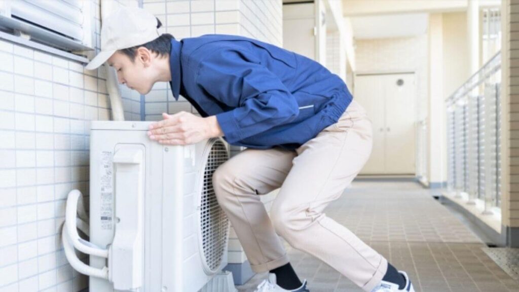 エアコンの室外機を設置する業者の男性